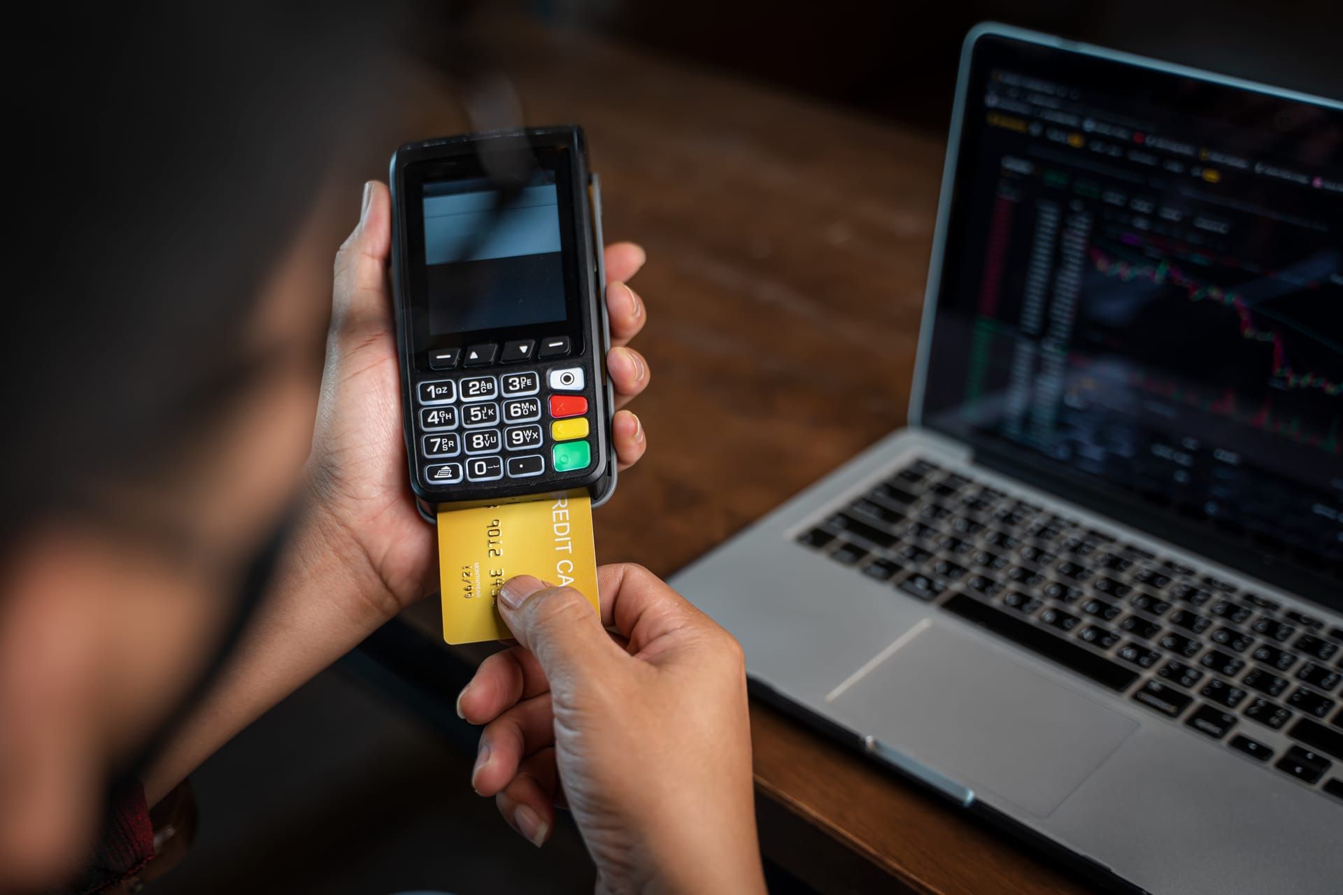 Man holding credit card while using laptop for online payment